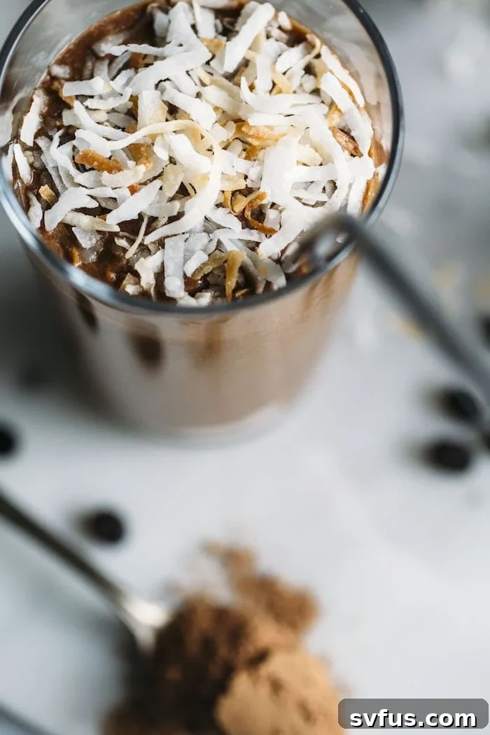 A close-up shot of a healthy Toasted Coconut Espresso Smoothie, showcasing its creamy texture and the golden brown toasted coconut flakes on top, highlighting its tropical appeal.