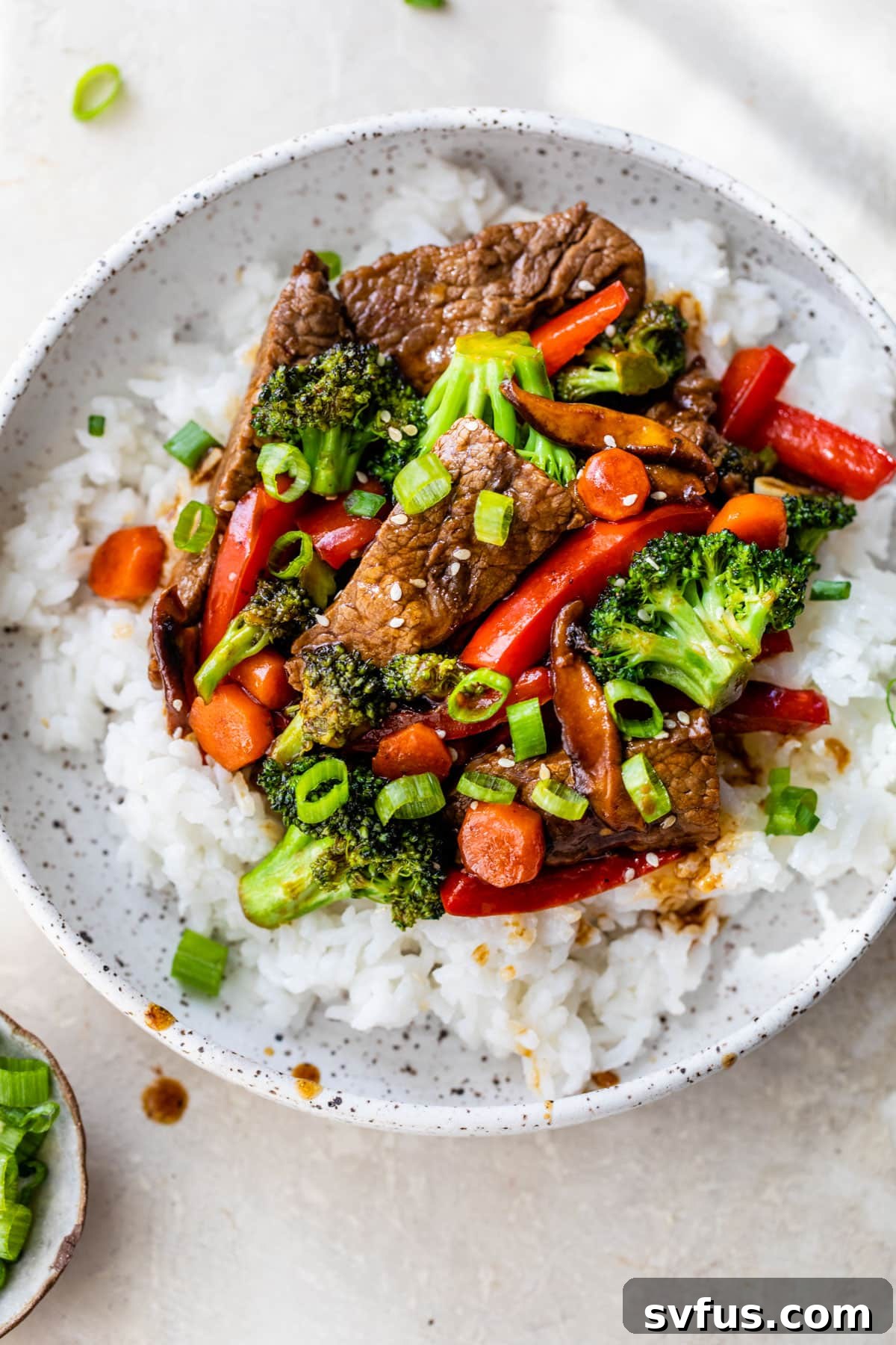 Another enticing bowl of beef stir fry, featuring tender beef and a colorful mix of broccoli and carrots, served over rice.