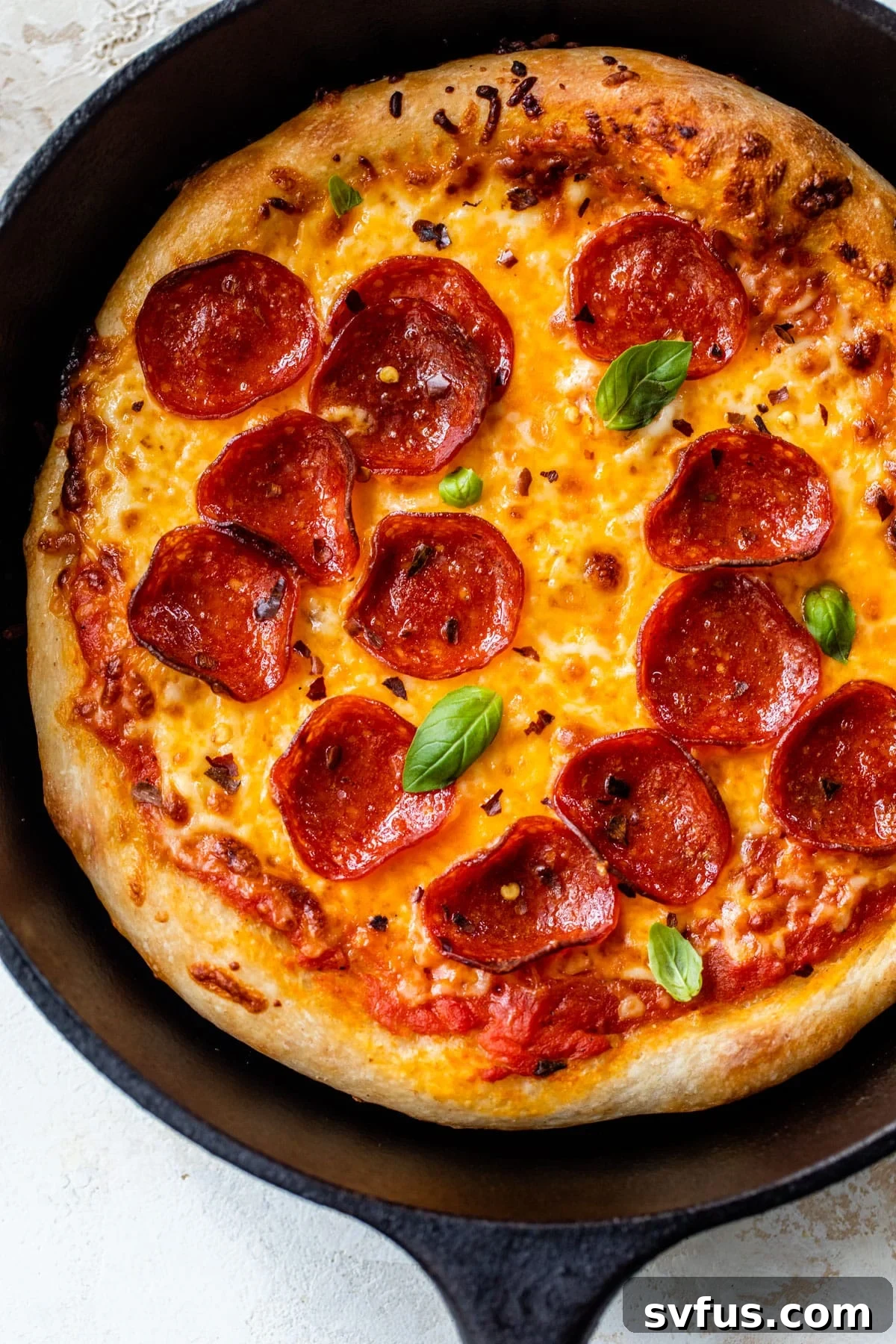 pepperoni pizza in a cast iron skillet, golden brown and bubbling