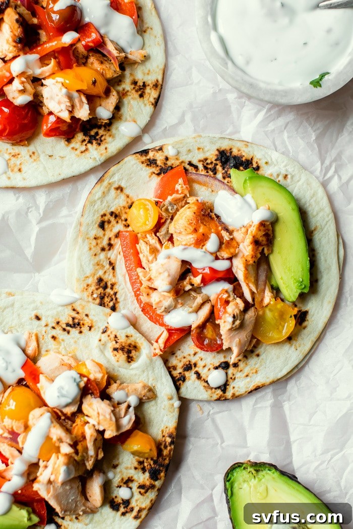 blackened salmon fajitas served on flour tortillas with avocado slices and a creamy sauce