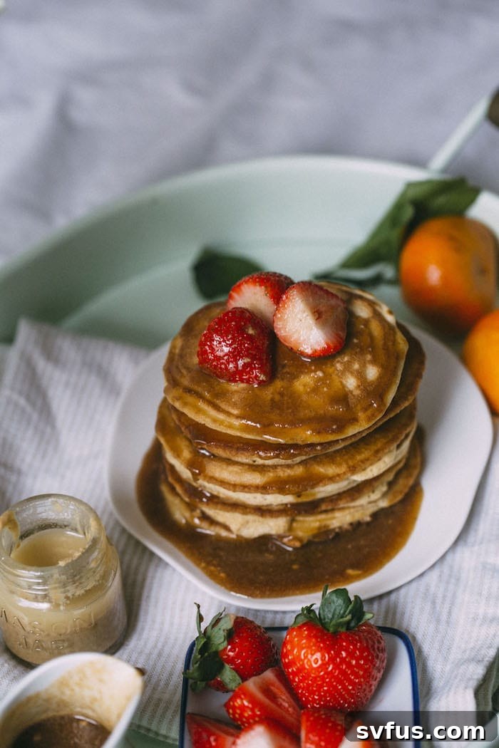 Fluffy Cinnamon Tahini Pancakes topped with syrup, tahini, and cinnamon drizzle