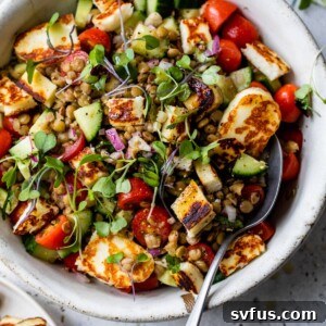 A vibrant bowl of Halloumi Lentil Salad with fried halloumi, fresh vegetables, and lentils.
