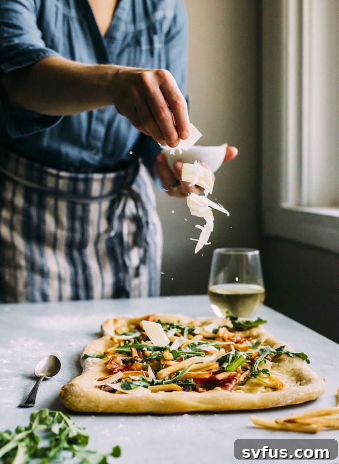 Close-up of a White Truffle Pizza from thealmondeater.com, showcasing melted cheese, mushrooms, and prosciutto