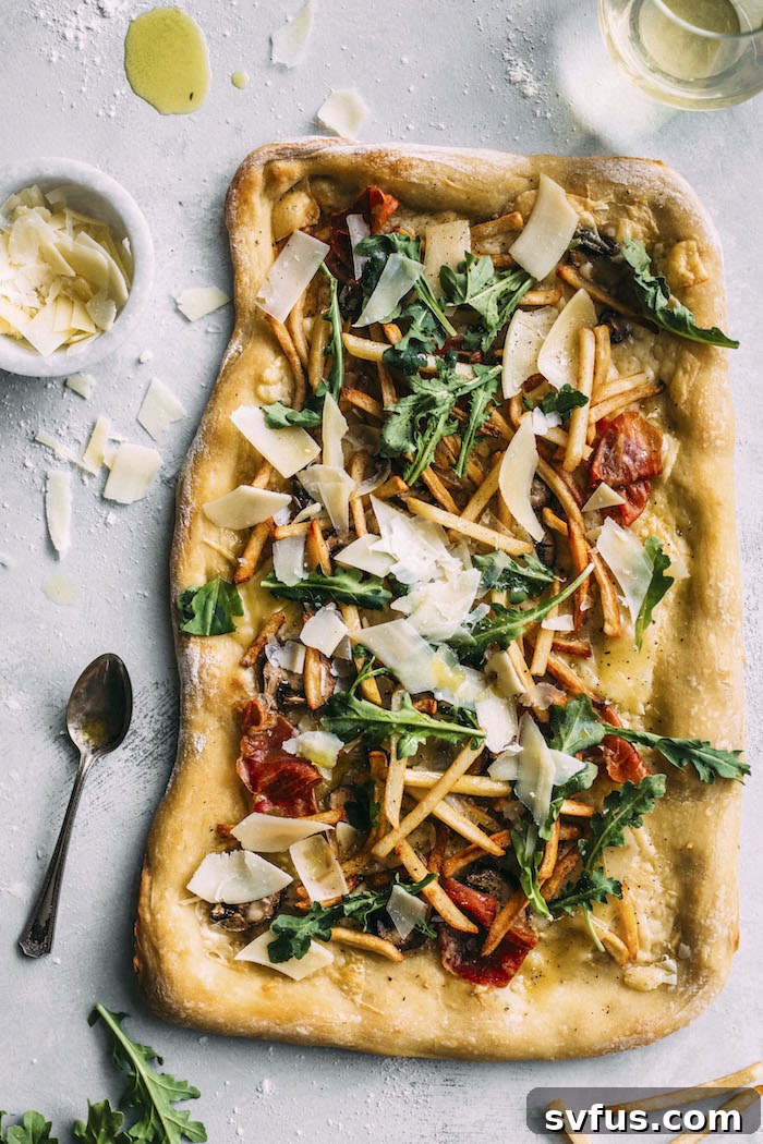 White Truffle Pizza garnished with fresh arugula and French fries, ready to be served