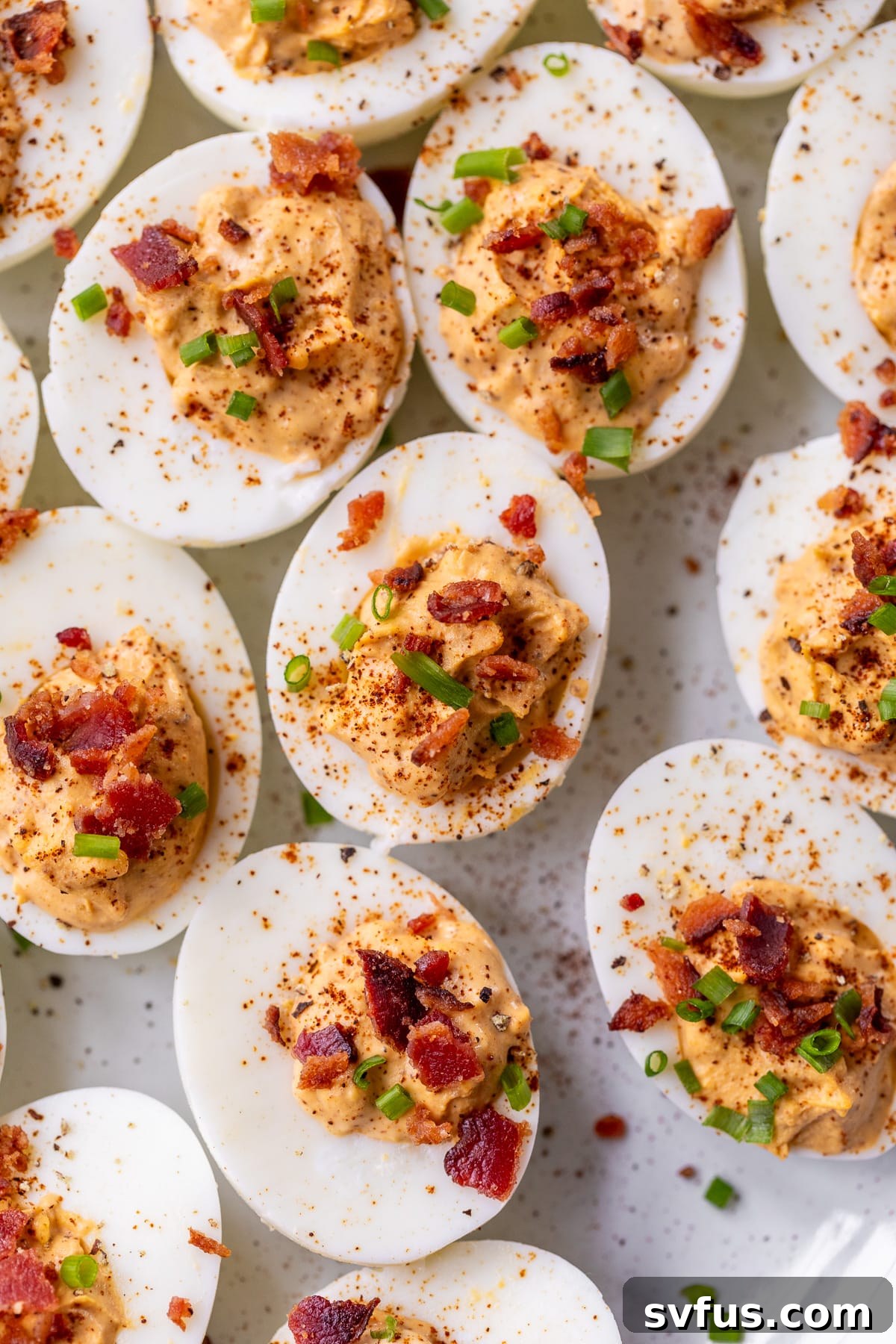 Close-up of chipotle deviled eggs topped with chives on a serving platter