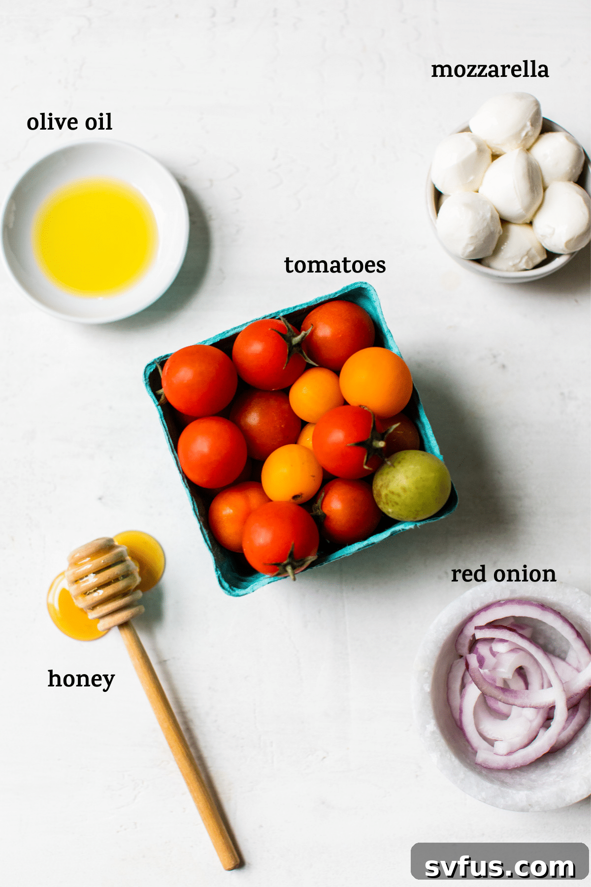 Food on a table, including a bowl of honey roasted tomatoes and mozzarella