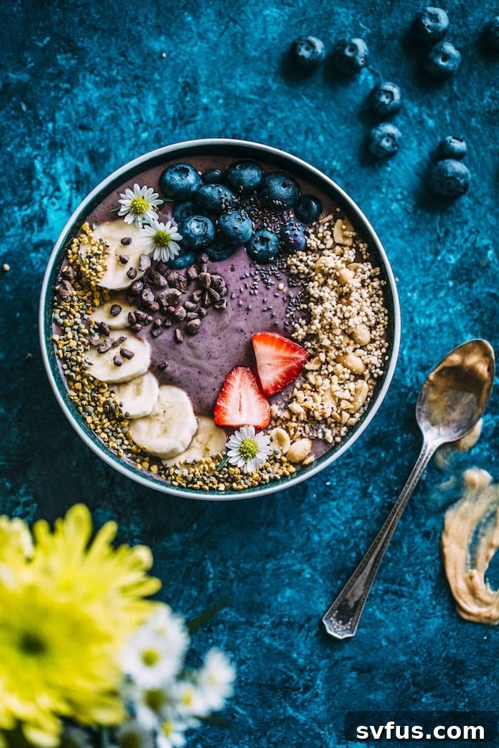 A vibrant acai bowl topped with fresh fruit, granola, and a drizzle of peanut butter, showcasing a healthy and delicious breakfast option.