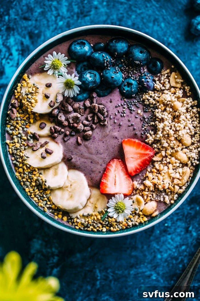 A close-up shot of a purple acai smoothie in a bowl, ready for toppings, highlighting its vibrant color and smooth texture.