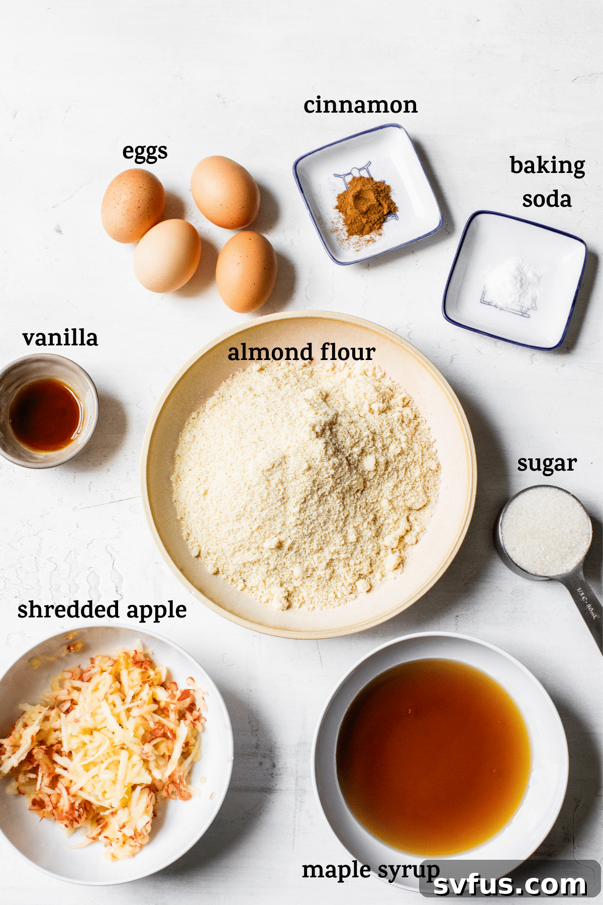 Fresh ingredients laid out for baking gluten-free apple cupcakes, including almond flour, sugar, eggs, and freshly shredded apples, with a warm, inviting text overlay.