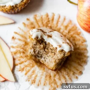 A gluten-free apple cupcake with a bite taken out, showing the moist crumb and fluffy icing.