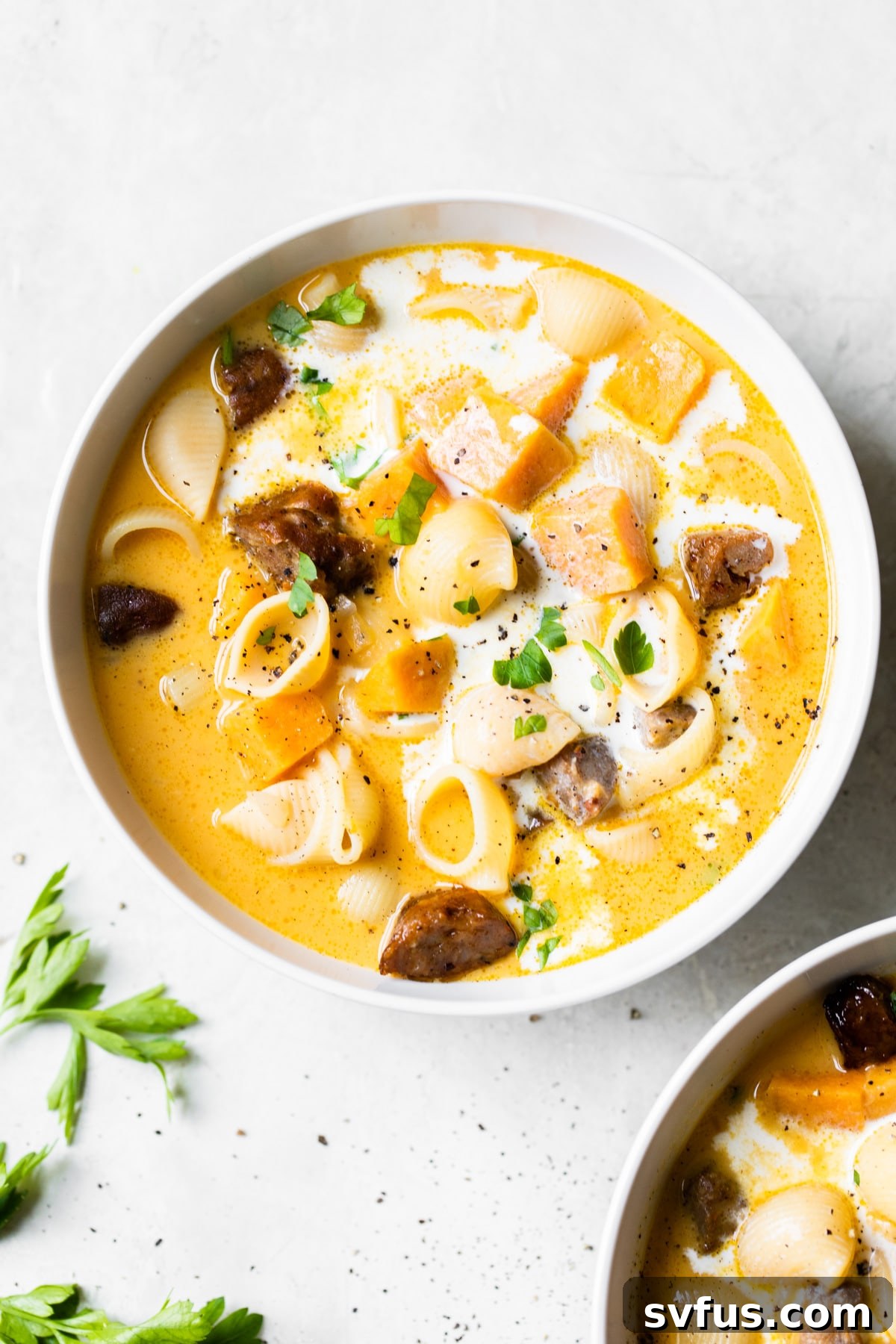 A perfectly portioned bowl of Chorizo Sweet Potato Soup with a spoon