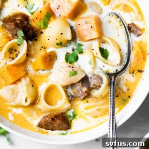 Close-up of a bowl of Chorizo Sweet Potato Soup with a spoon