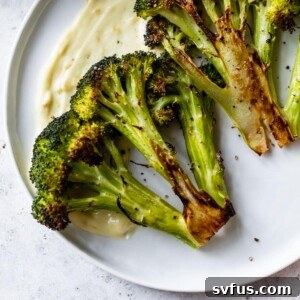 roasted broccoli crowns on a white plate with aioli