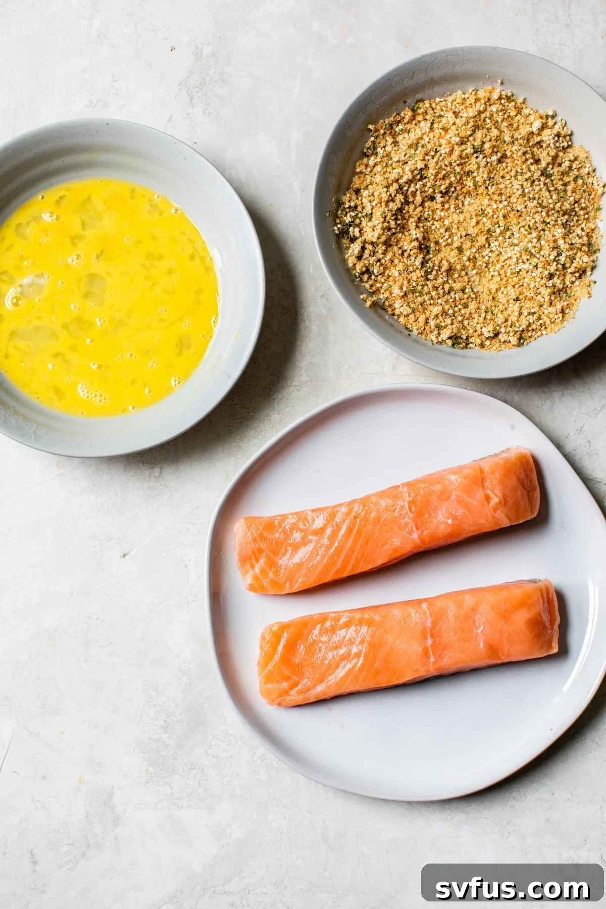 Two bowls are prepared for breading: one with whisked egg and the other with a mixture of quinoa, breadcrumbs, and seasonings.