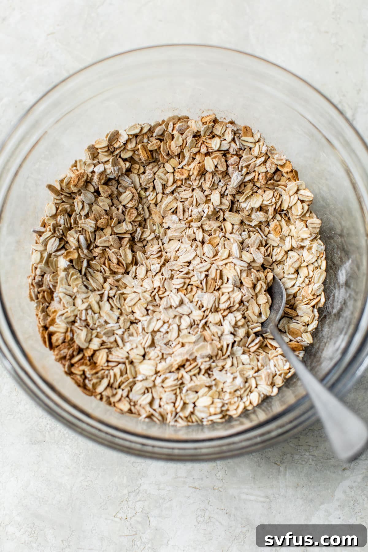 A bowl filled with dry rolled oats, ready for mixing.