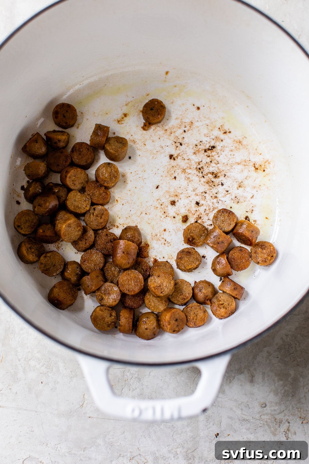 cooked sausage in a white dutch oven
