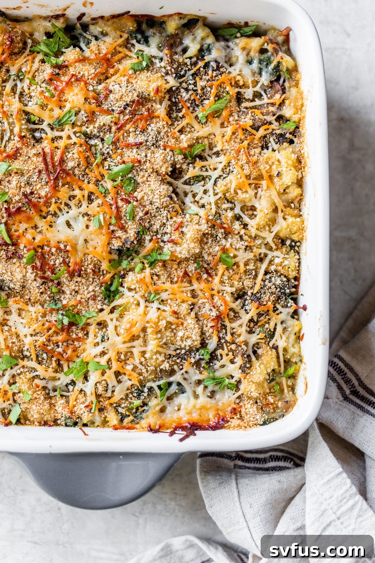 A casserole dish filled with baked vegan cauliflower gratin, topped with golden breadcrumbs, viewed from above.