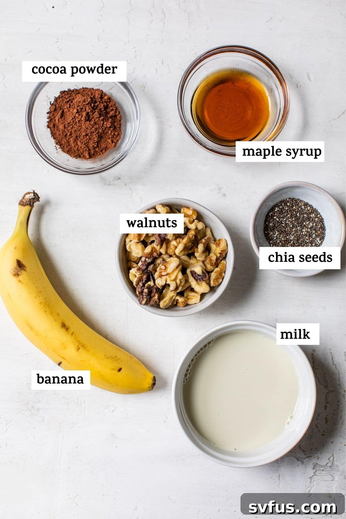 Assortment of fresh smoothie ingredients including bananas, walnuts, and cocoa powder on a rustic table