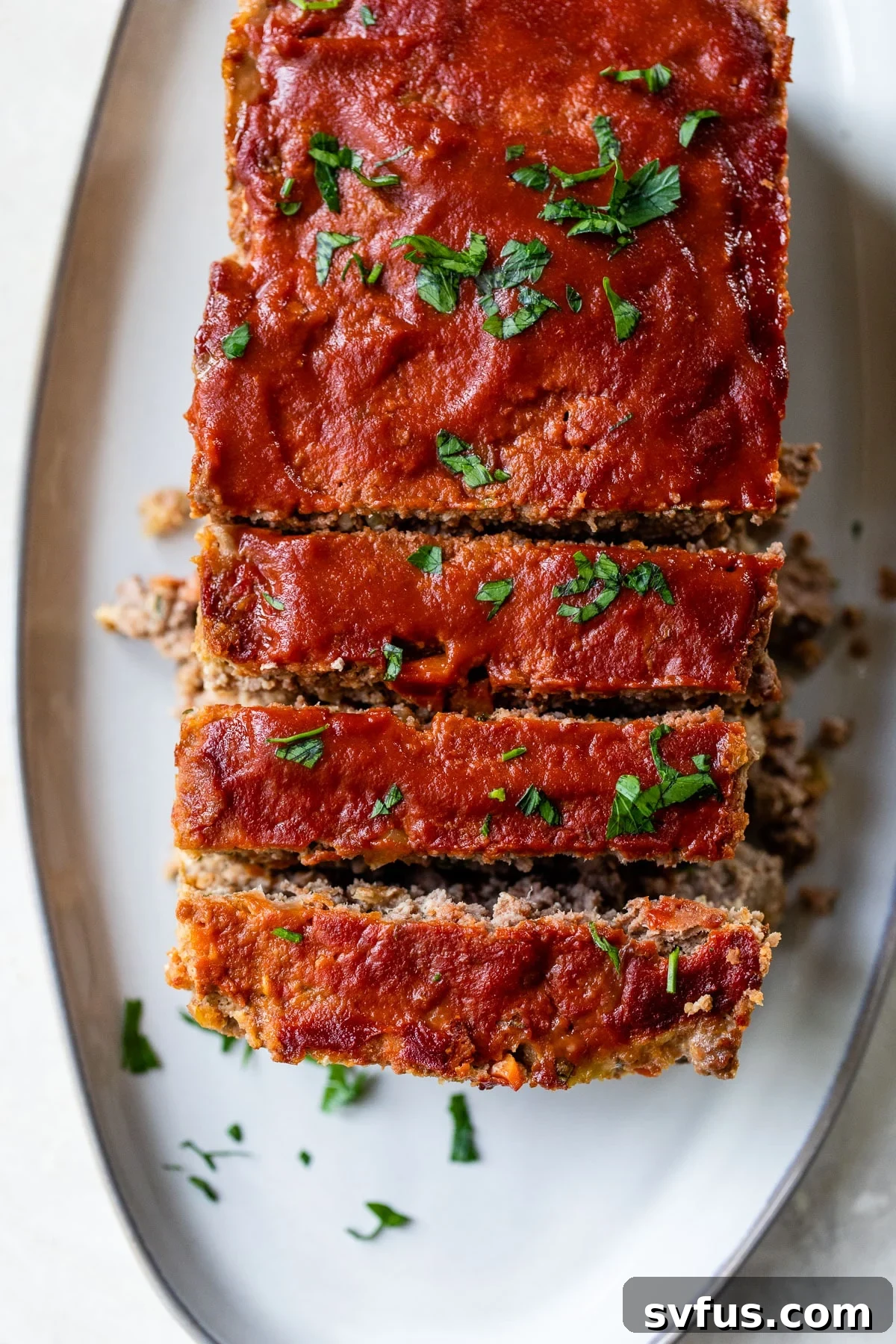 A perfectly sliced loaf of Whole30 meatloaf on a serving platter, ready to be enjoyed.