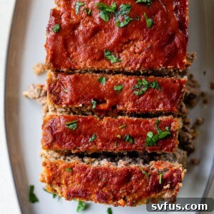 A beautifully sliced loaf of Whole30 meatloaf on a serving platter, showcasing its tender texture.