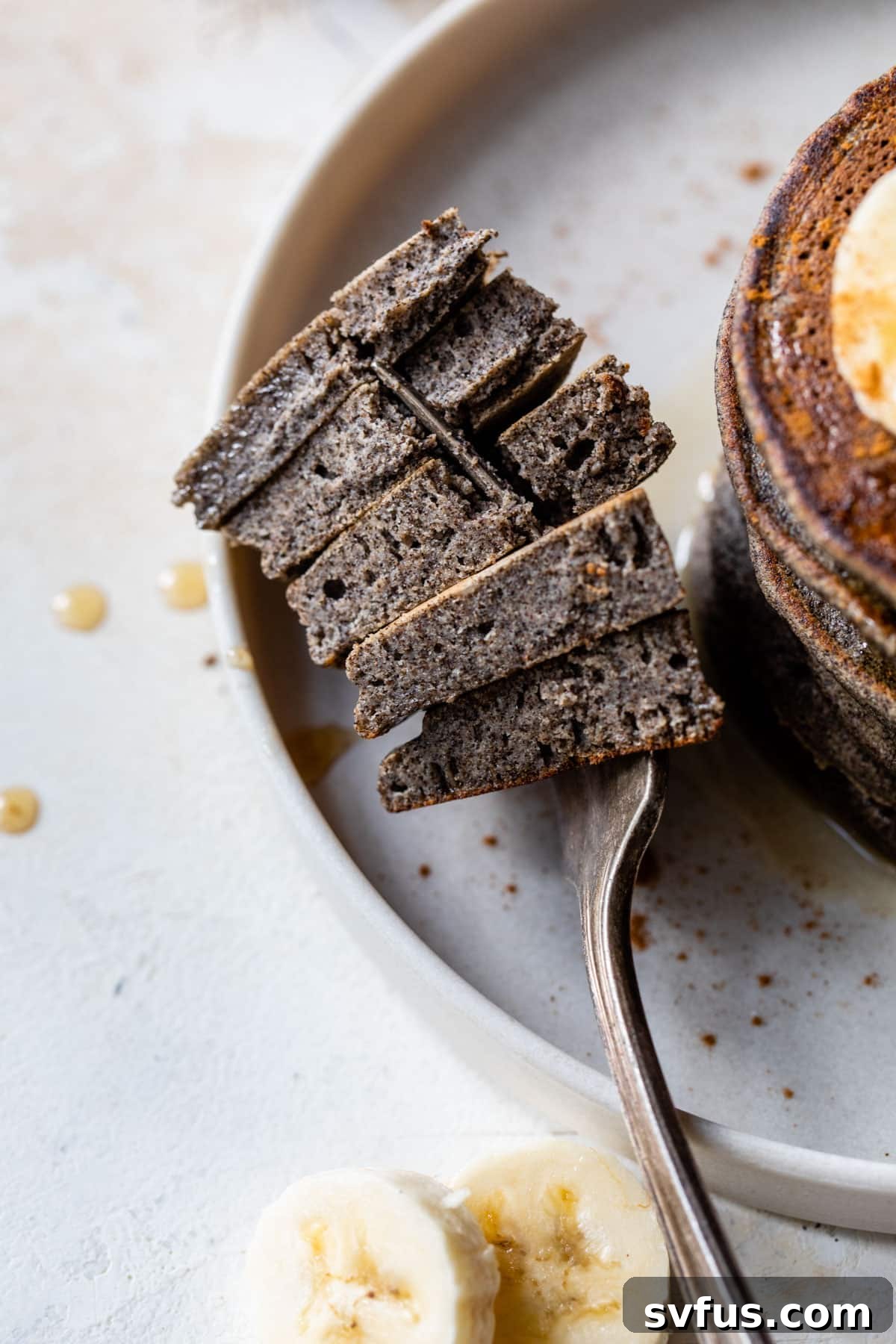 A fork with a bite-sized piece of buckwheat pancake, showing its texture