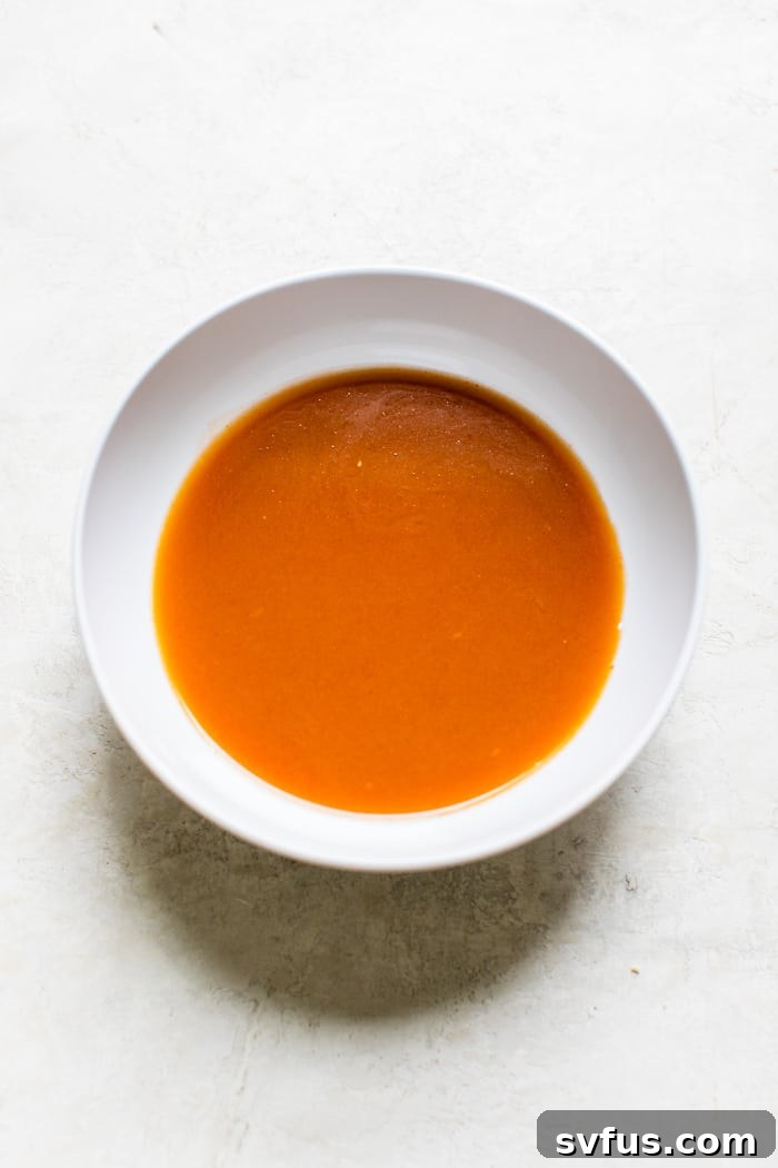 Ingredients for Asian-style sauce being whisked together in a ceramic bowl