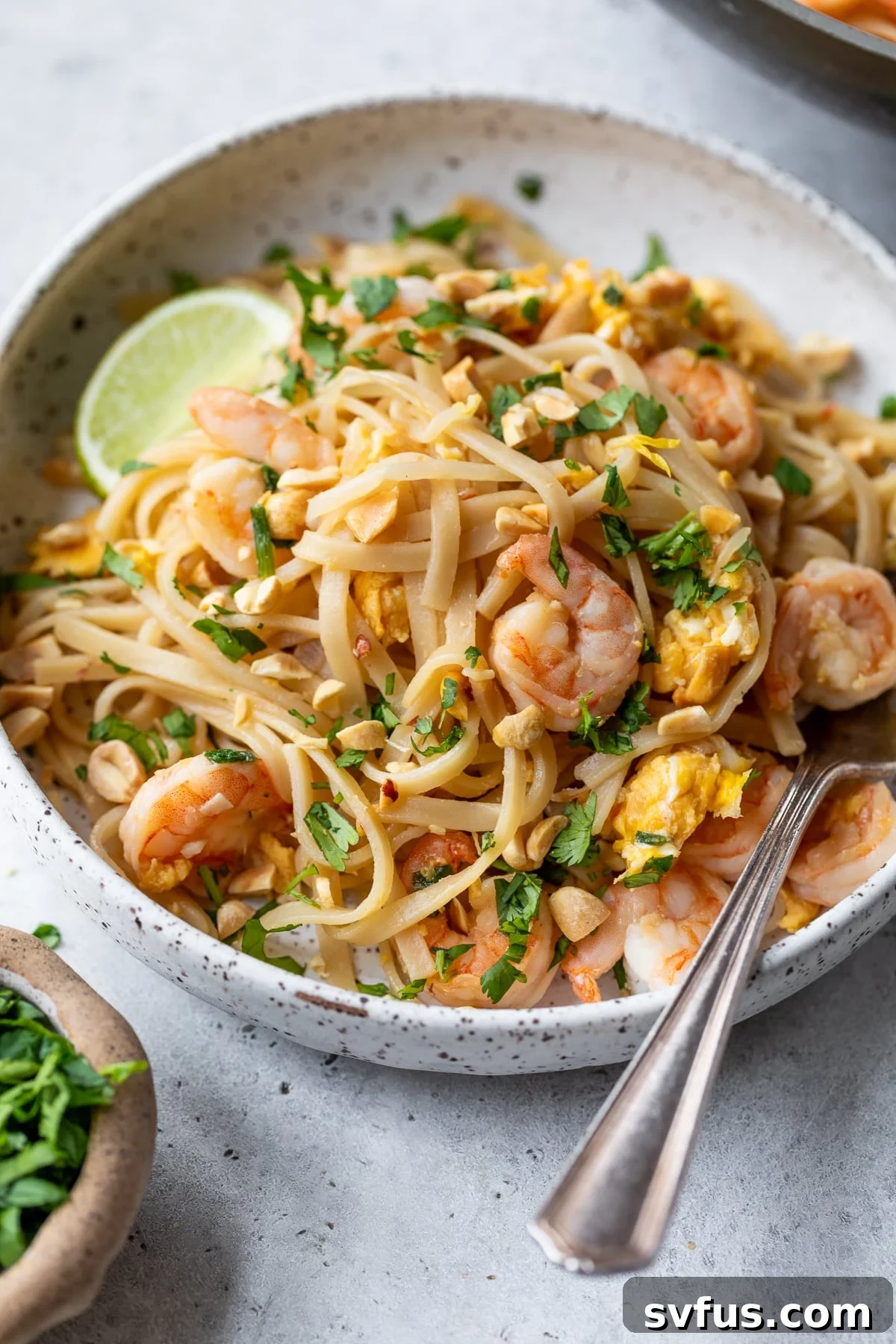 A vibrant bowl of homemade Shrimp Pad Thai with a fork, ready to be enjoyed.