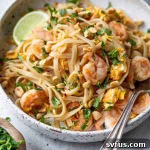 shrimp pad thai in a bowl with a fork