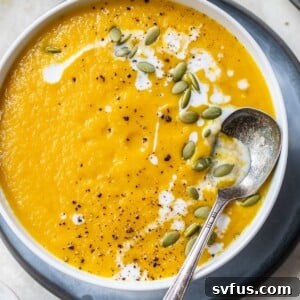 a bowl of blended soup topped with pumpkin seeds