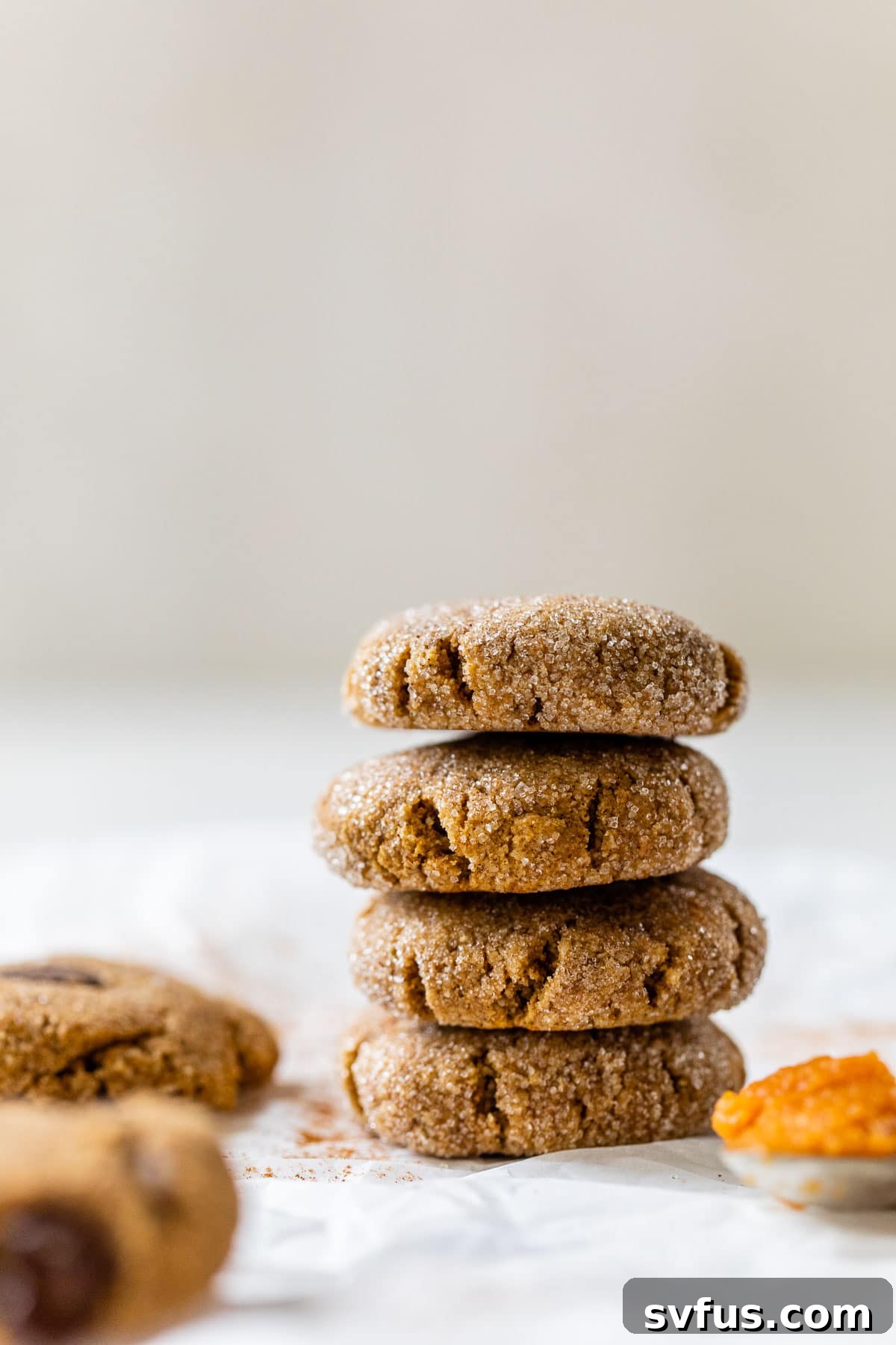 a stack of healthy pumpkin cookies coated in a delicate sugar dusting, perfect for fall baking