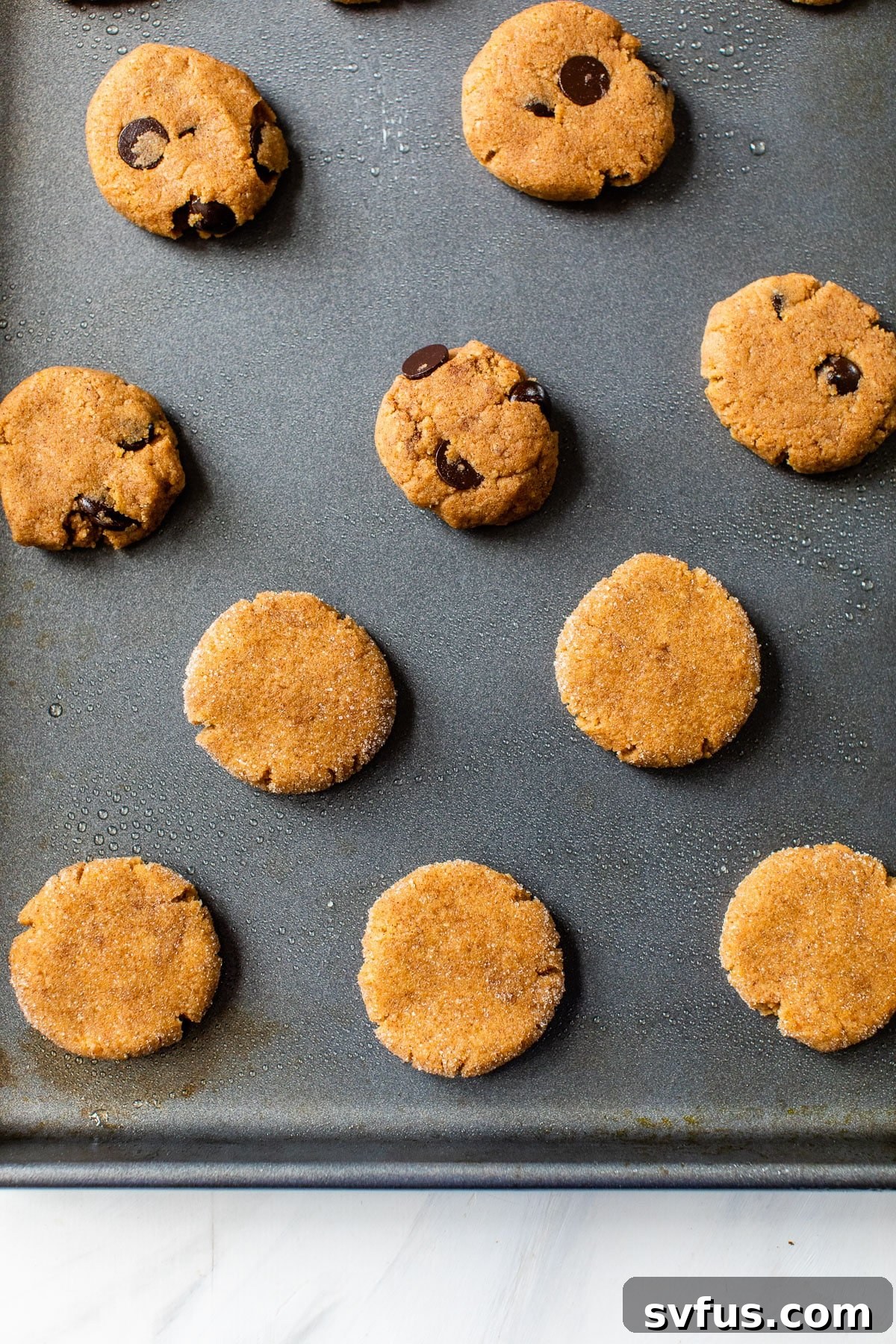 raw pumpkin cookies perfectly spaced on a parchment-lined baking sheet, ready for the oven