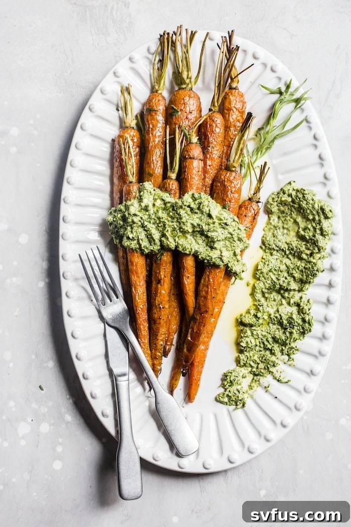 Close-up view of the vibrant green Tarragon Carrot Top Pesto in a bowl, showcasing its smooth texture and fresh ingredients. The pesto is a perfect topping for the roasted carrots.