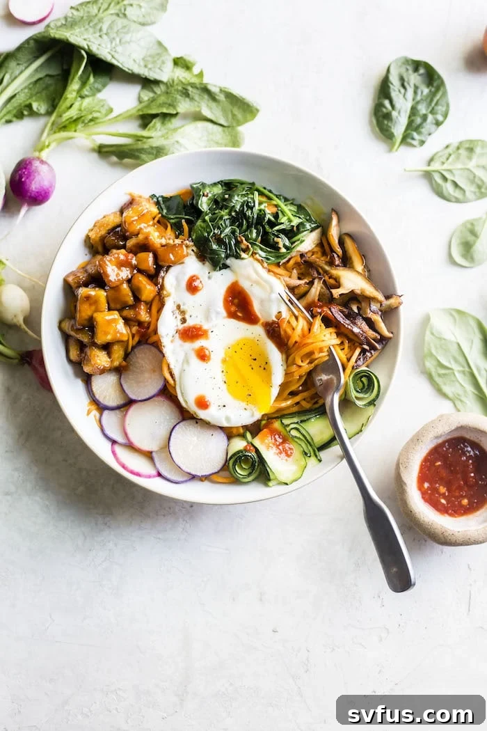 Tofu Sweet Potato Bibimbap ready to be enjoyed, highlighting the sunny-side-up egg