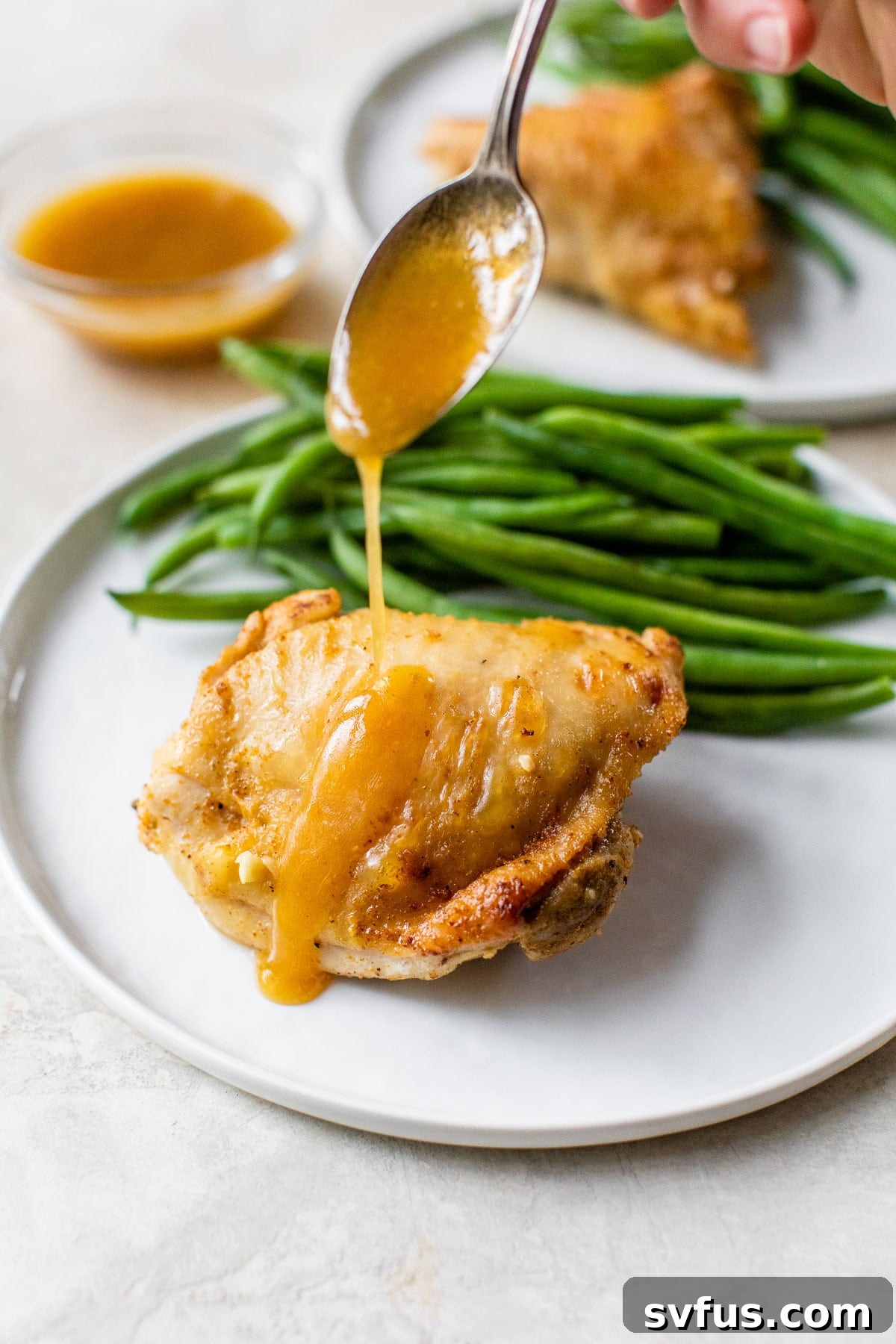 Drizzling rich gravy over a perfectly cooked, crispy chicken thigh