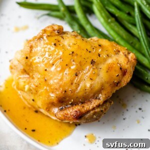 chicken thigh on a plate with gravy and green beans