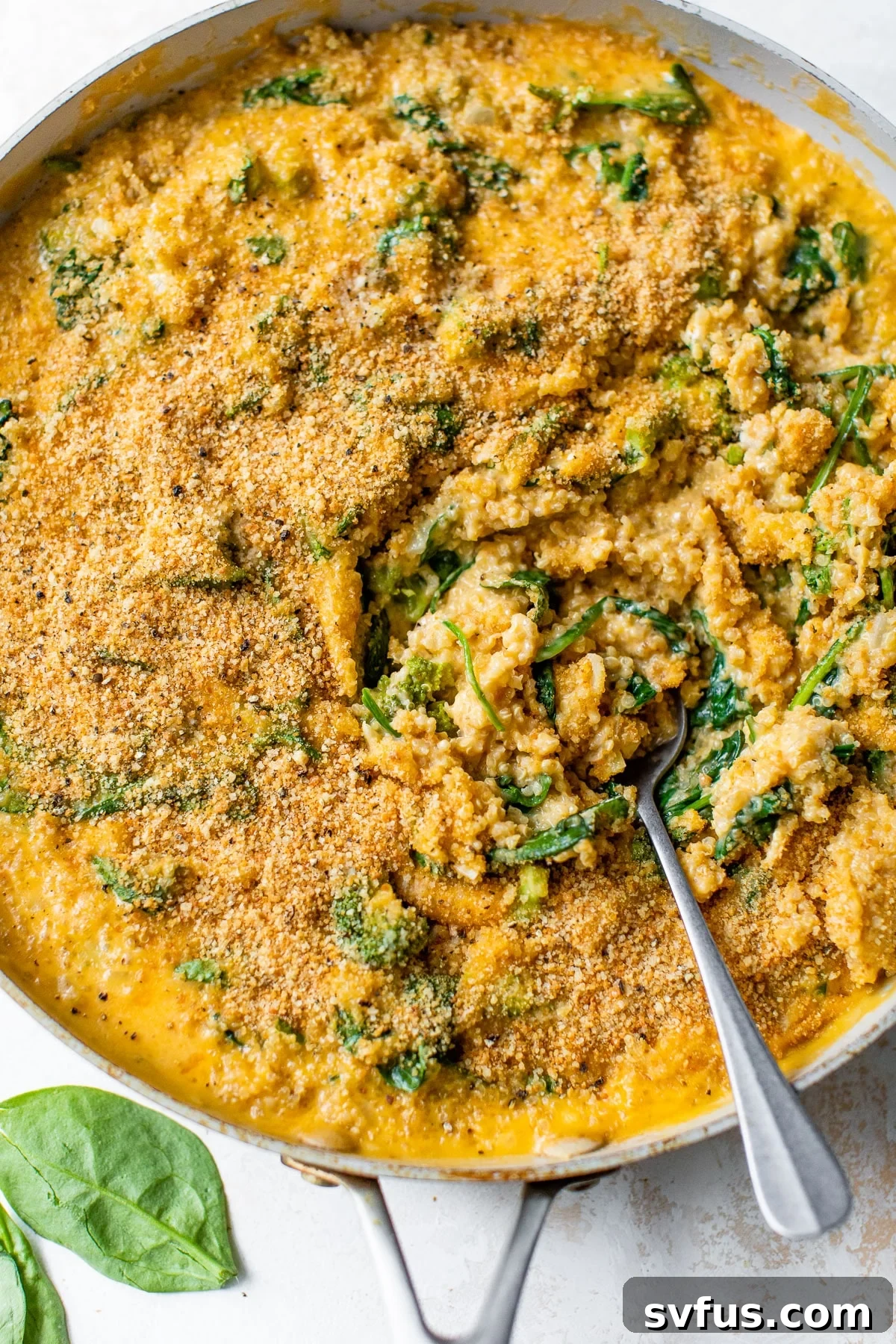 mac and cheese with quinoa and spinach in a skillet