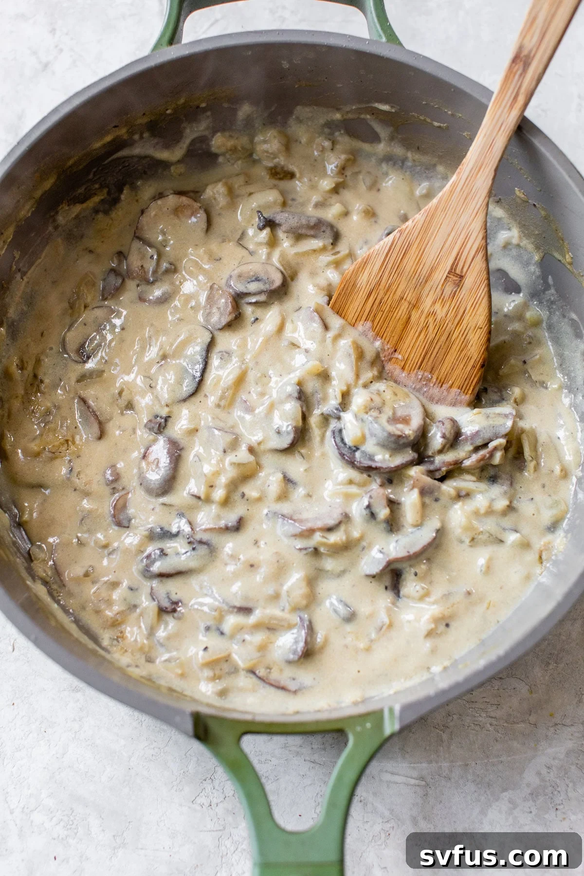 Creamy vegan mushroom sauce simmering in a skillet, ready to be combined with cooked pasta.
