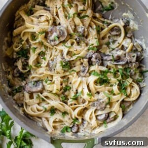 pasta tossed in mushroom sauce in a skillet