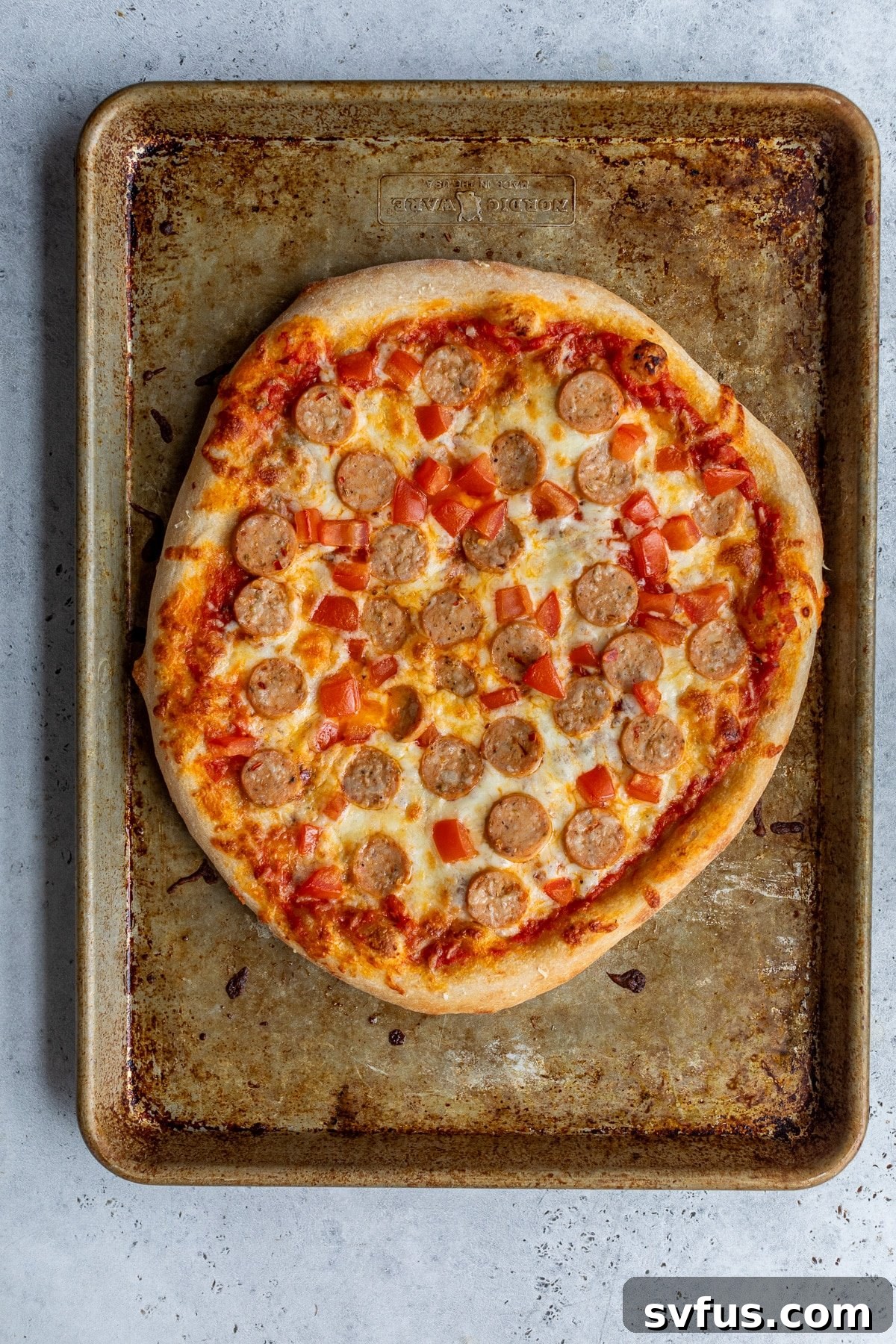 chicken sausage pizza on a baking sheet