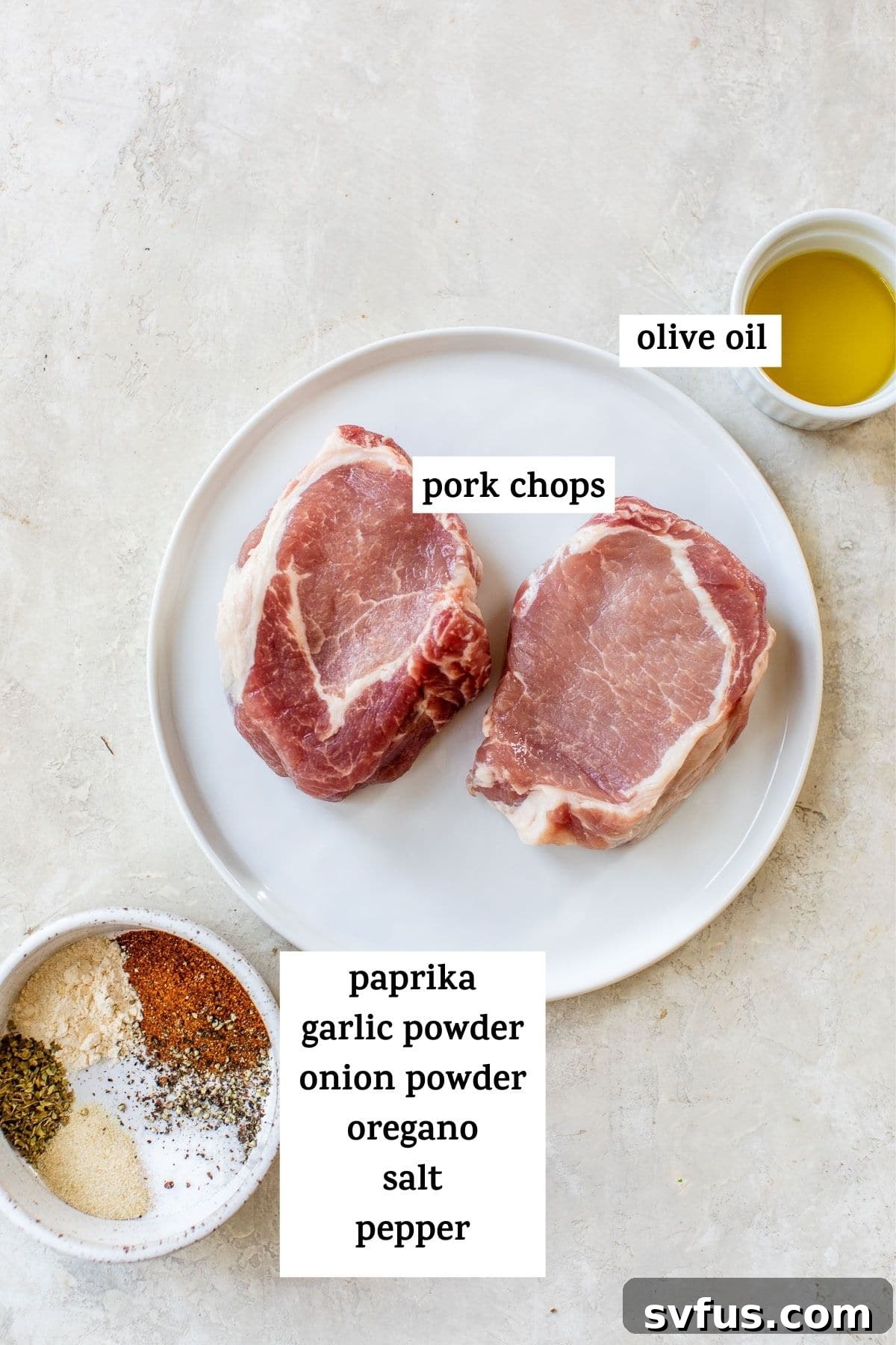 Raw boneless pork chops arranged on a plate alongside a small bowl filled with a blend of spices.