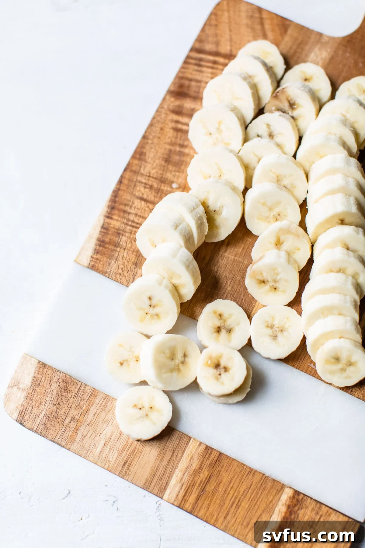Freshly sliced banana rounds, perfectly arranged on a cutting board, ready for the next step in creating delicious banana bites.