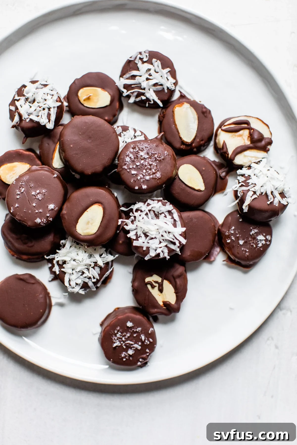 A simple yet inviting plate of frozen chocolate peanut butter banana bites, elegantly coated and ready to be enjoyed as a refreshing and healthy dessert.