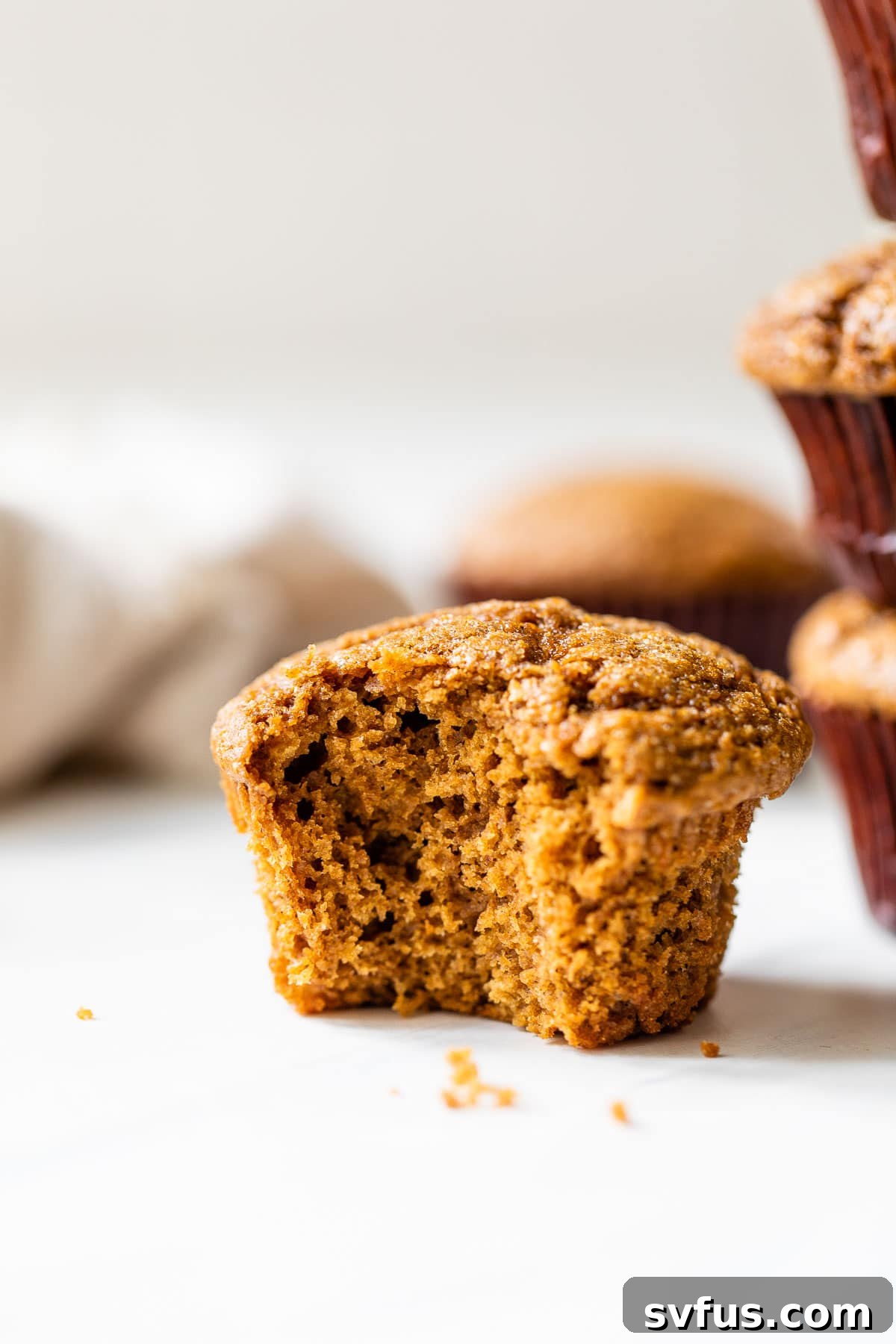 A healthy gingerbread muffin with a bite taken out of it, revealing its soft, moist interior and delicious spices.
