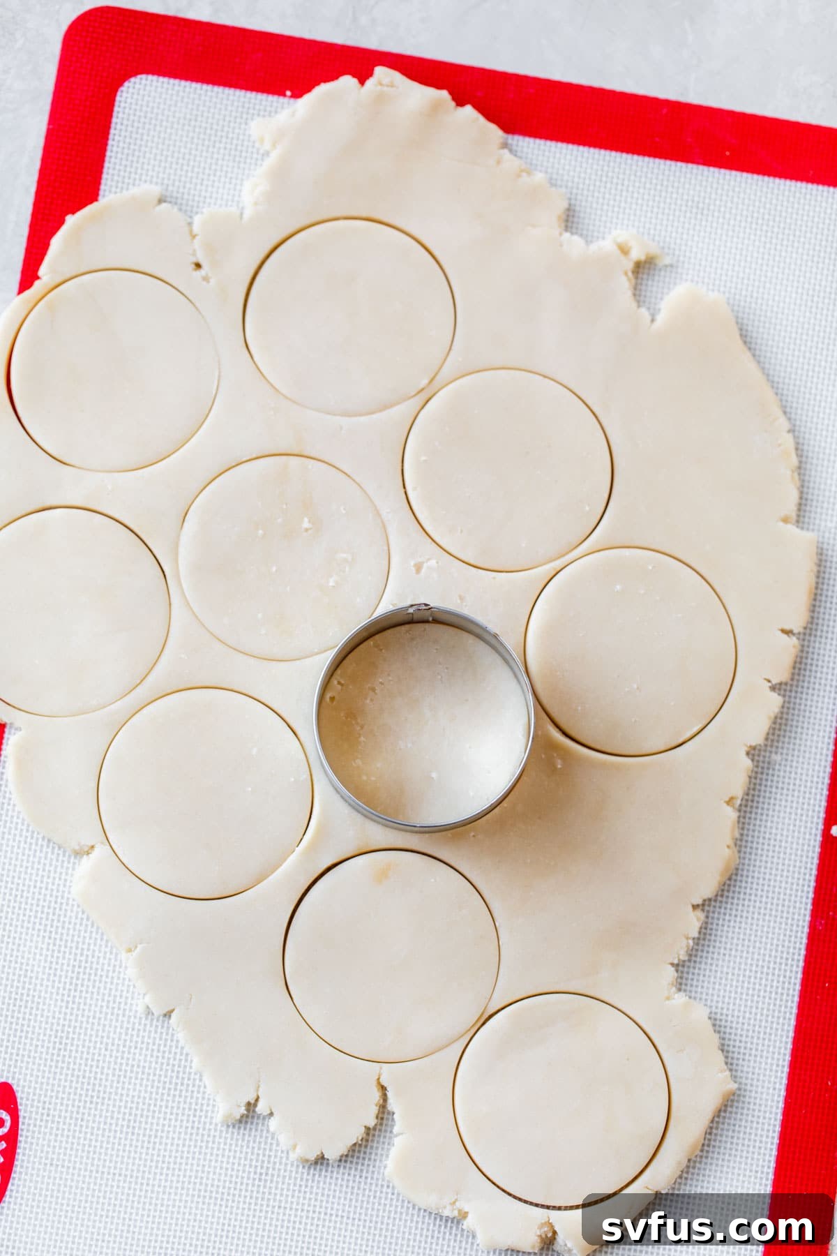Rolled out cookie dough with a round cookie cutter on top, ready for cutting.