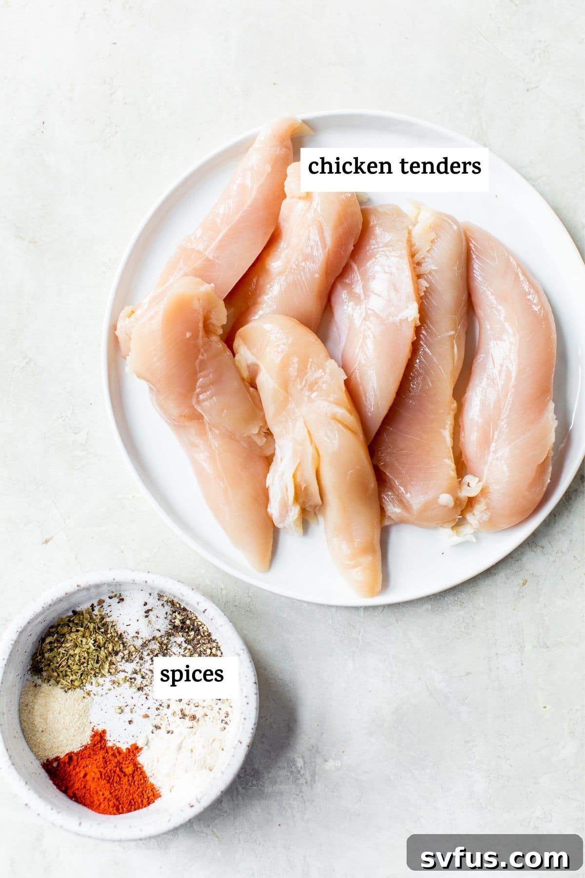 Raw chicken tenders seasoned with a vibrant mix of spices in a bowl