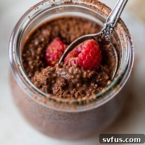 glass jar filled with chia pudding topped with raspberries
