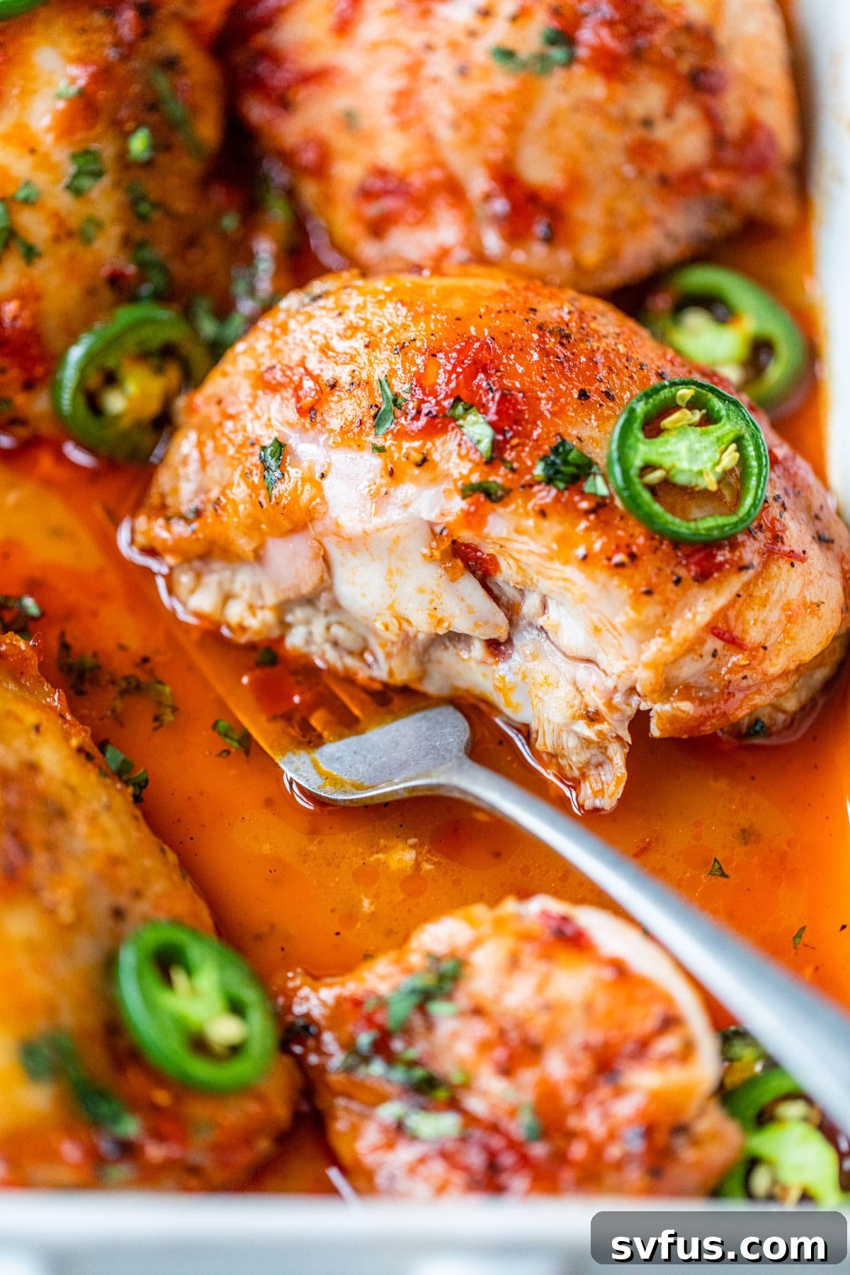 someone cutting into a cooked chicken thigh