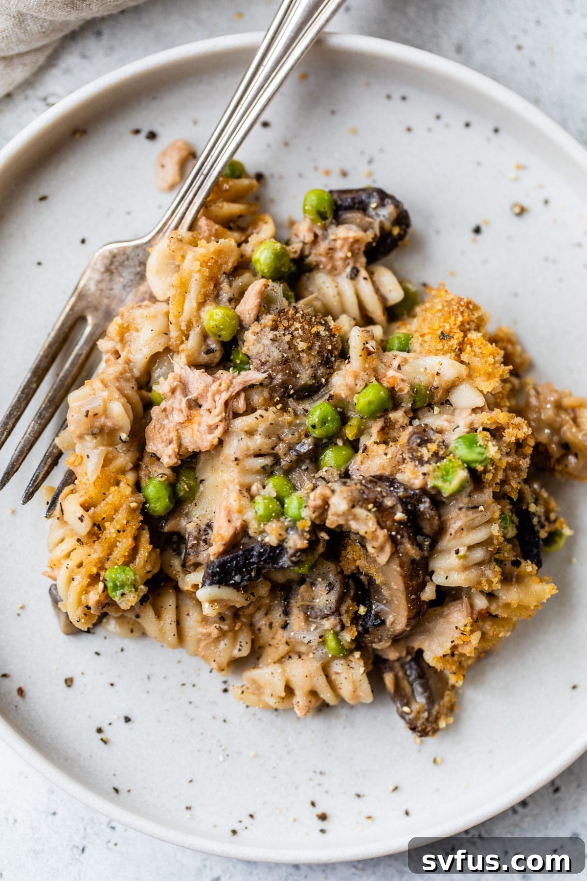 A plate with a generous serving of healthy tuna noodle casserole and a fork, highlighting its creamy texture