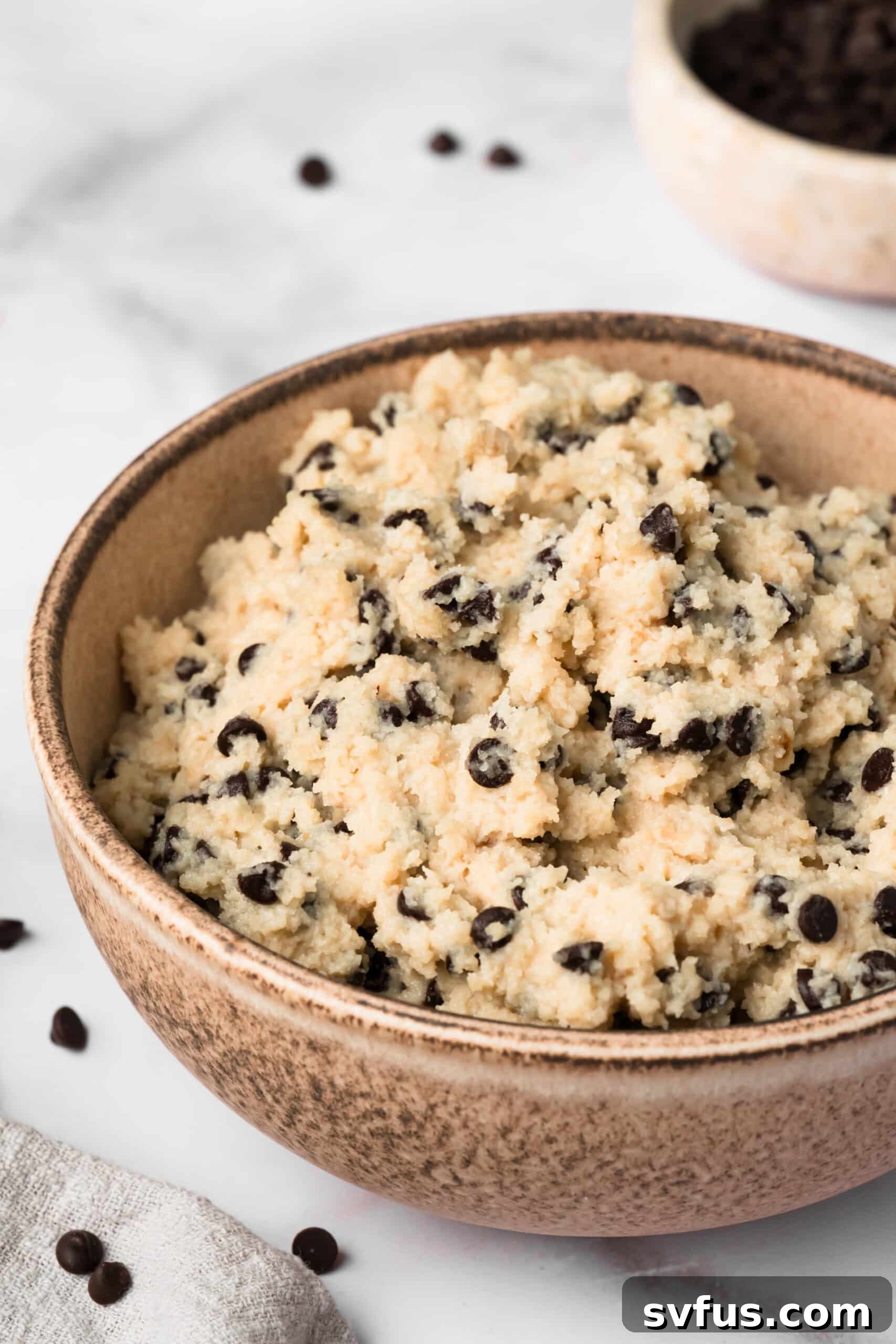 Side view of chocolate chip cottage cheese cookie dough in a bowl.