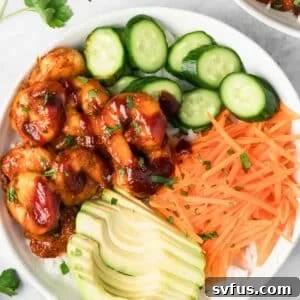 overhead view of a BBQ Shrimp Bowl topped with shrimp, cucumbers, carrots, and avocado.